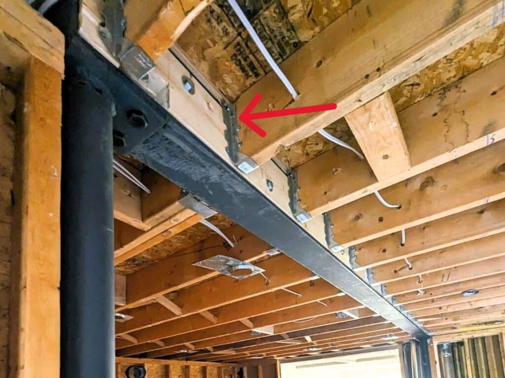 Ceiling Joists held in place to new beam via hangers in this wall removal reno.